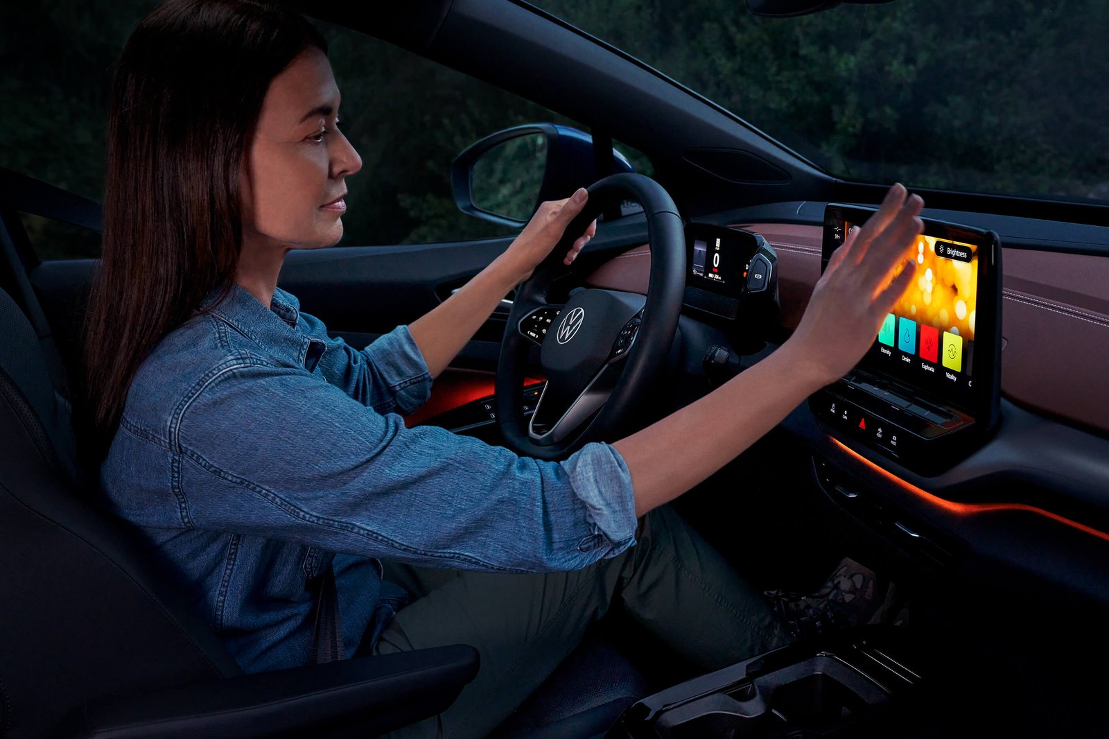 A woman sits in the driver’s seat of an ID.4 and adjusts the ambient lighting settings.