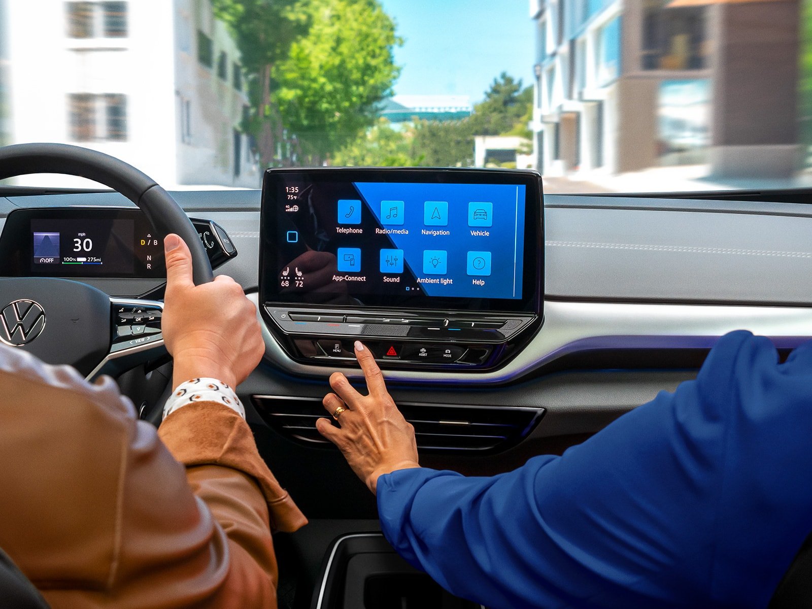 A close-up shot of an ID.4 dashboard, focusing on the passenger reaching out for the available 12” touchscreen
                        display.